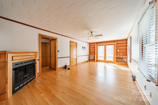 unfurnished living room with ornamental molding, heating unit, light wood-type flooring, and french doors