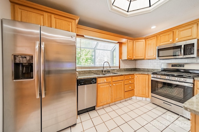 kitchen with sink, light tile patterned floors, appliances with stainless steel finishes, tasteful backsplash, and dark stone counters