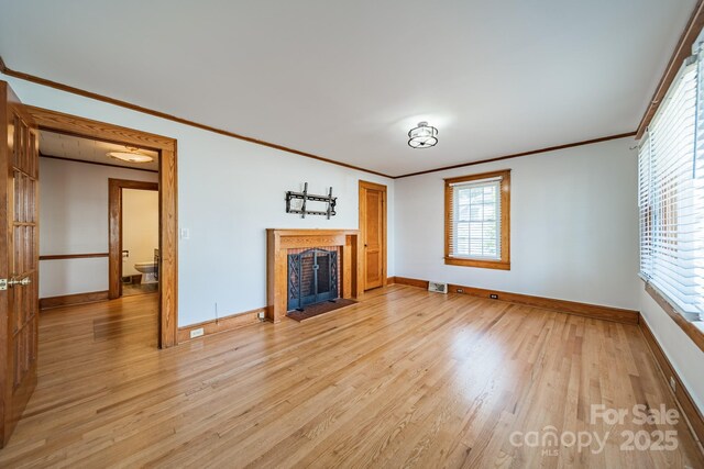 531 Elm St, Salisbury, NC 28144 - unfurnished living room featuring baseboards, crown molding, light wood-type flooring, plenty of natural light, and a fireplace with flush hearth