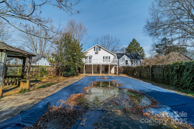 531 Elm St, Salisbury, NC 28144 - back of property featuring concrete driveway, stairs, a wooden deck, and a fenced backyard