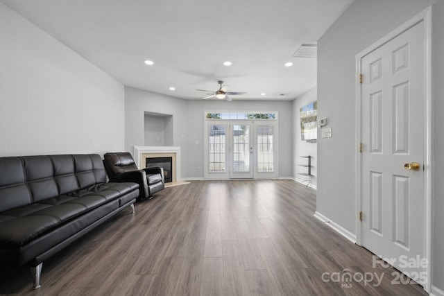 living room featuring dark wood-type flooring and ceiling fan