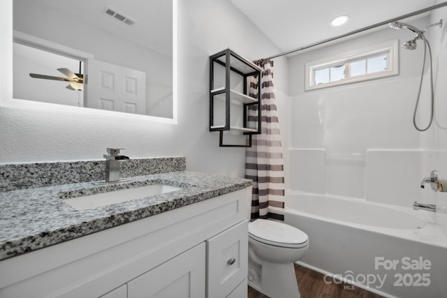 full bathroom with hardwood / wood-style floors, vanity, ceiling fan, toilet, and shower / bath combo