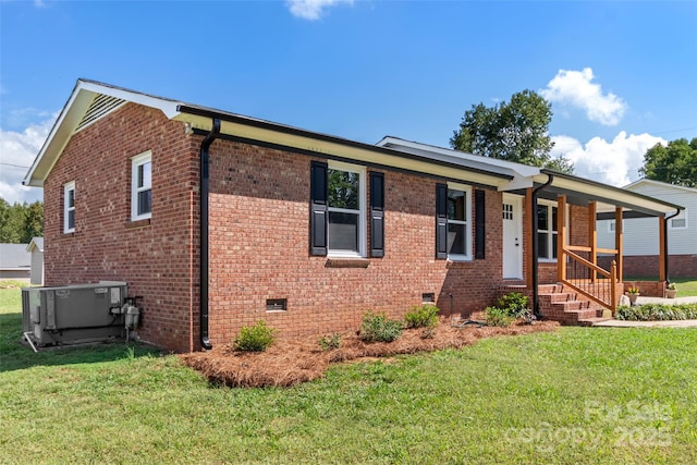 view of front facade with central AC unit, covered porch, and a front lawn