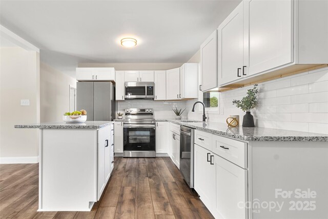 2525 Oxford Cir, Lancaster, SC 29720 - kitchen with sink, light stone counters, a center island, appliances with stainless steel finishes, and white cabinets