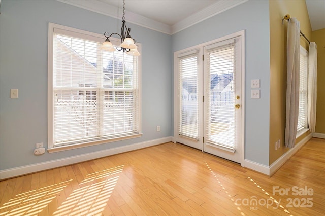 unfurnished dining area with crown molding, wood-type flooring, and a chandelier