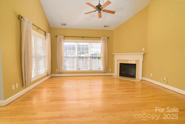 unfurnished living room featuring vaulted ceiling, a healthy amount of sunlight, and light wood-type flooring