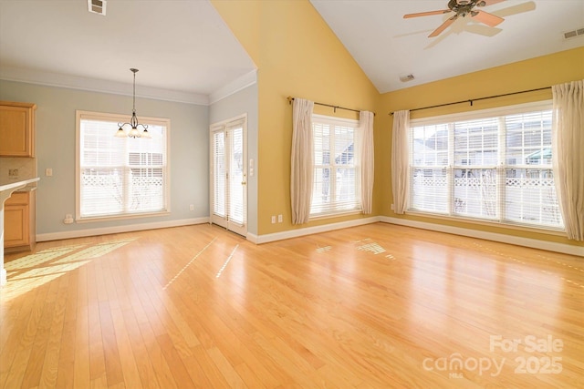 unfurnished living room with vaulted ceiling, ornamental molding, ceiling fan with notable chandelier, and light hardwood / wood-style flooring