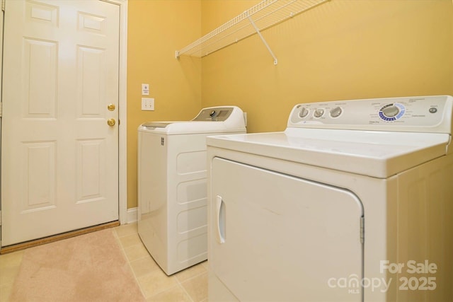 washroom featuring washer and dryer and light tile patterned floors