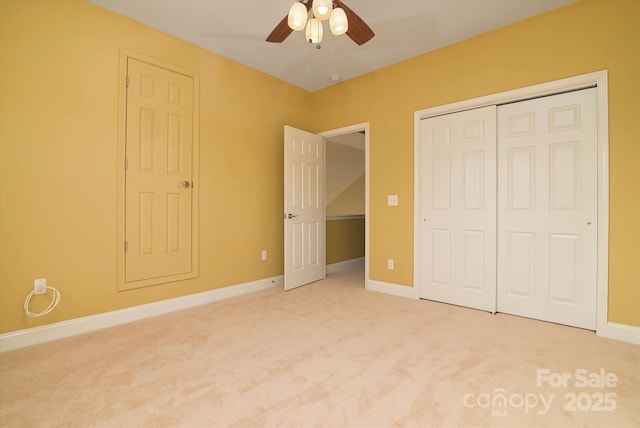 unfurnished bedroom featuring ceiling fan, a closet, and light carpet