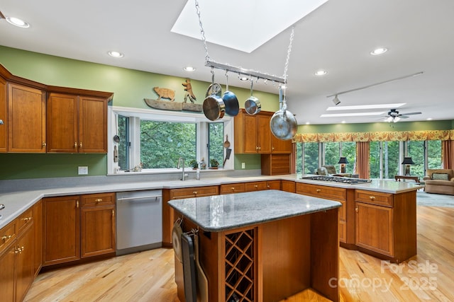 kitchen featuring sink, a skylight, a center island, and appliances with stainless steel finishes