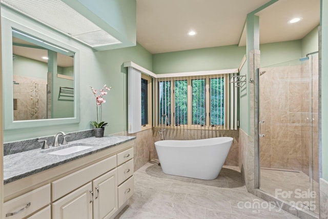 bathroom with vanity, plus walk in shower, and tile walls