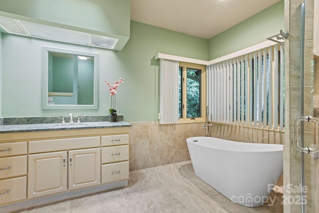 bathroom with vanity, plus walk in shower, and tile walls