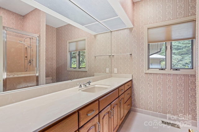 bathroom with tile patterned flooring, vanity, a shower, and toilet