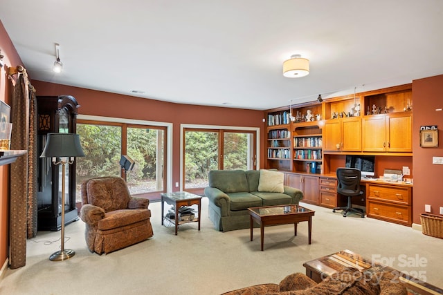 carpeted living room with built in desk