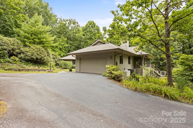 view of front of house with a garage and cooling unit