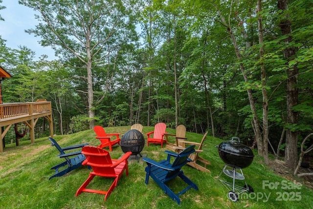 view of yard with a wooden deck and an outdoor fire pit