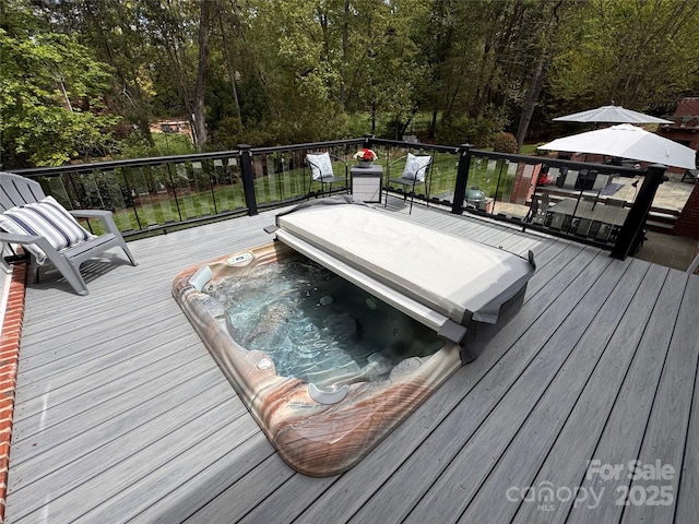 deck with a wooded view and hot tub deck surround