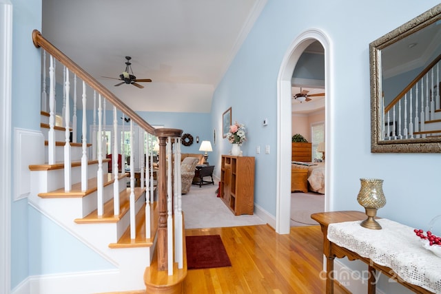 entrance foyer featuring ceiling fan, ornamental molding, lofted ceiling, and light wood-type flooring