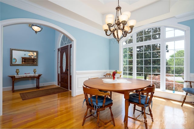 dining space featuring a notable chandelier, crown molding, and light hardwood / wood-style flooring