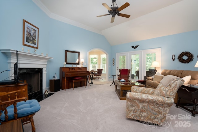 carpeted living room featuring crown molding, ceiling fan, lofted ceiling, and a premium fireplace