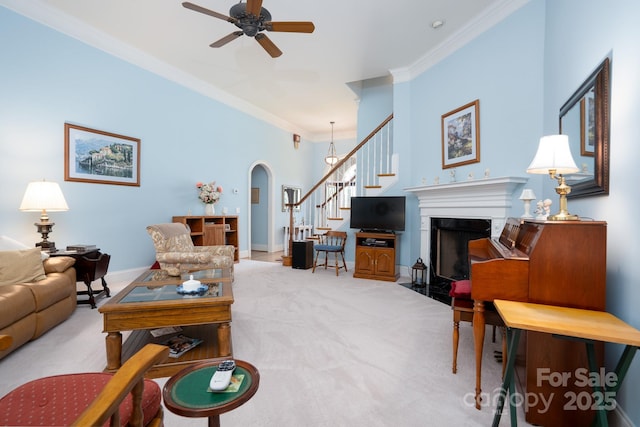 carpeted living room featuring crown molding and ceiling fan