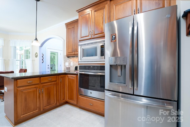 kitchen with crown molding, appliances with stainless steel finishes, tasteful backsplash, decorative light fixtures, and kitchen peninsula