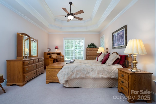 bedroom featuring a raised ceiling, ornamental molding, light carpet, and ceiling fan