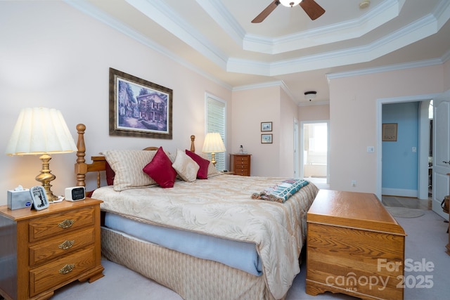 carpeted bedroom featuring crown molding, a raised ceiling, and ensuite bathroom