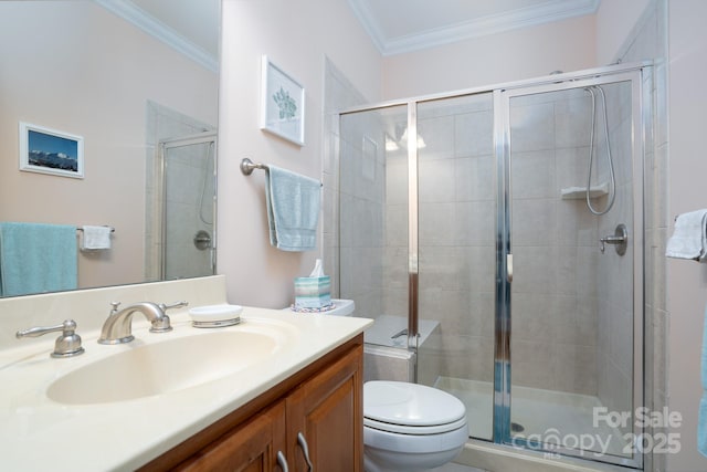 bathroom with crown molding, vanity, toilet, and a shower with door