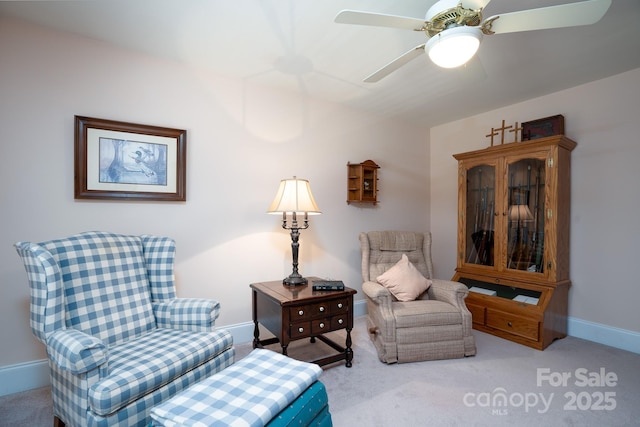 sitting room with ceiling fan and light colored carpet