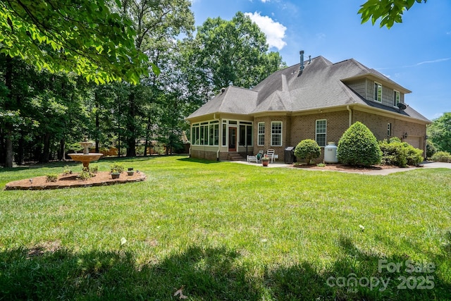 back of house featuring a patio, a sunroom, and a lawn