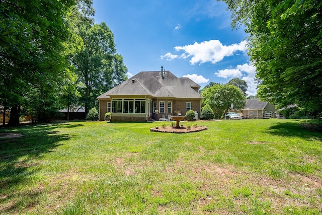 rear view of house featuring a yard