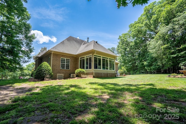 rear view of house featuring a lawn