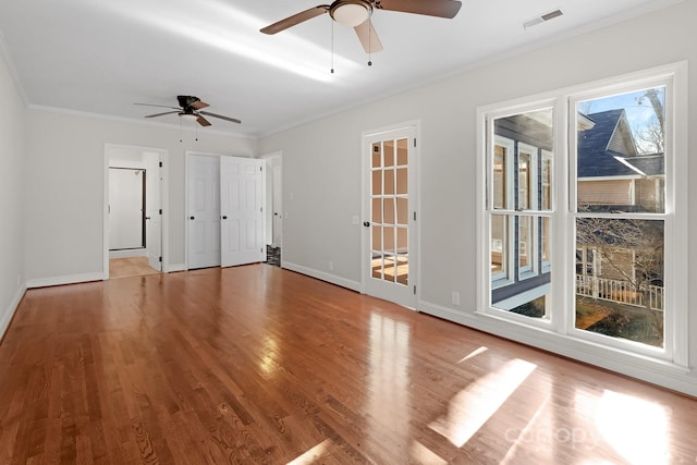 unfurnished room featuring ceiling fan, ornamental molding, light wood-type flooring, and a wealth of natural light