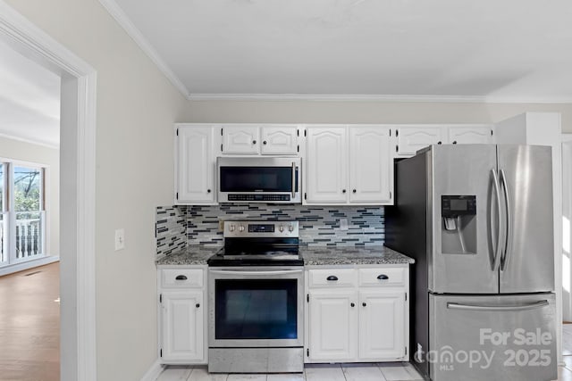 kitchen with white cabinetry, appliances with stainless steel finishes, decorative backsplash, and dark stone counters