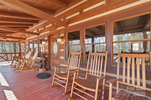 sunroom / solarium with beamed ceiling, a healthy amount of sunlight, and wood ceiling