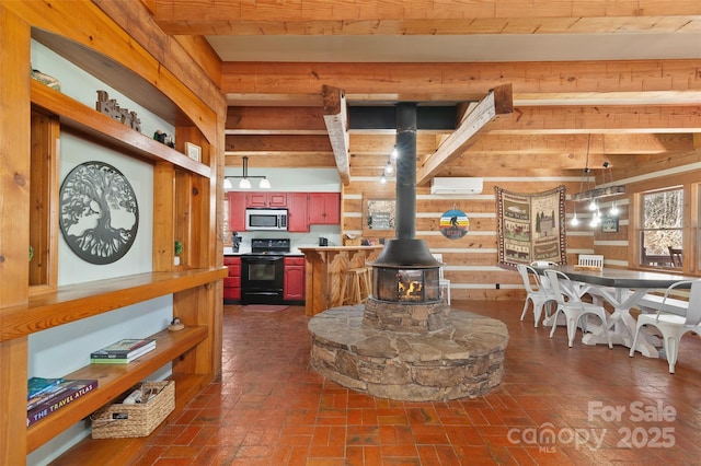 kitchen featuring an AC wall unit, wood walls, black electric range oven, a wood stove, and beam ceiling