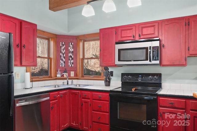 kitchen featuring a wealth of natural light, sink, tile counters, and black appliances