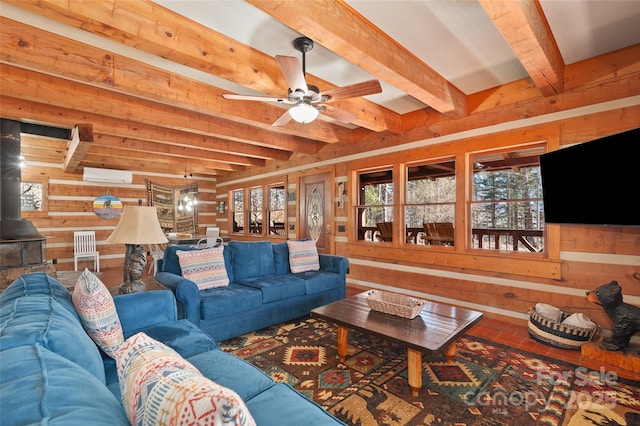 living room with an AC wall unit, wooden walls, beamed ceiling, a wood stove, and ceiling fan