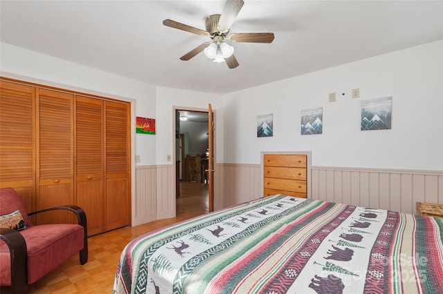 bedroom featuring ceiling fan, light parquet flooring, and a closet