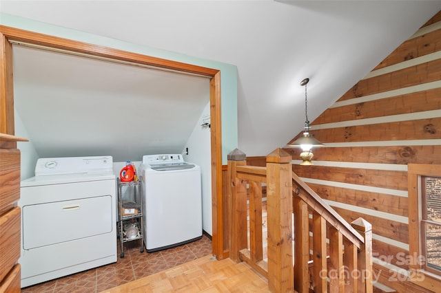 clothes washing area featuring washing machine and clothes dryer and light parquet floors