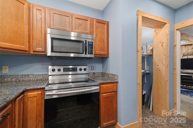 kitchen with appliances with stainless steel finishes and dark stone countertops