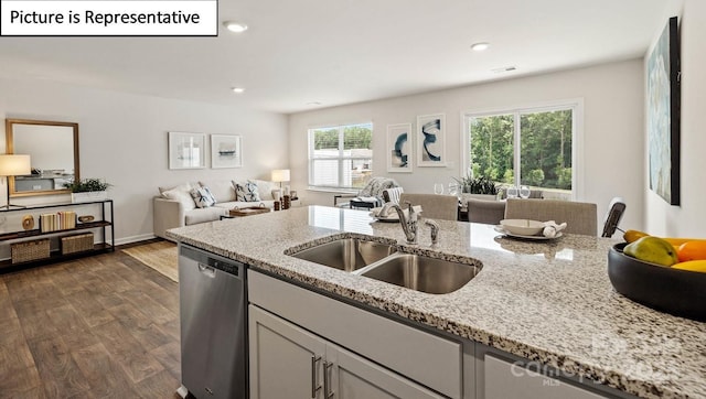 kitchen featuring light stone countertops, sink, stainless steel dishwasher, and dark wood-type flooring