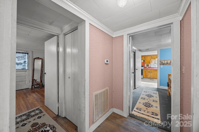 corridor with ornamental molding and dark wood-type flooring