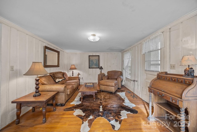 living room with crown molding and light wood-type flooring