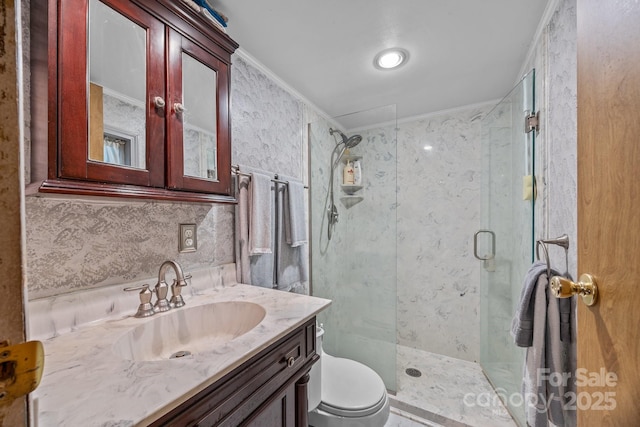 bathroom featuring ornamental molding, toilet, vanity, and walk in shower