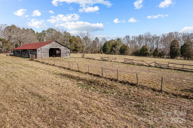 view of yard with a rural view and an outdoor structure