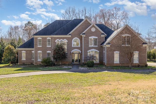 view of front of house with a front yard and brick siding