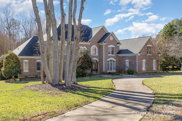 view of front of house featuring crawl space, brick siding, a front lawn, and concrete driveway