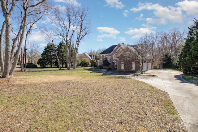 view of yard with a garage and concrete driveway